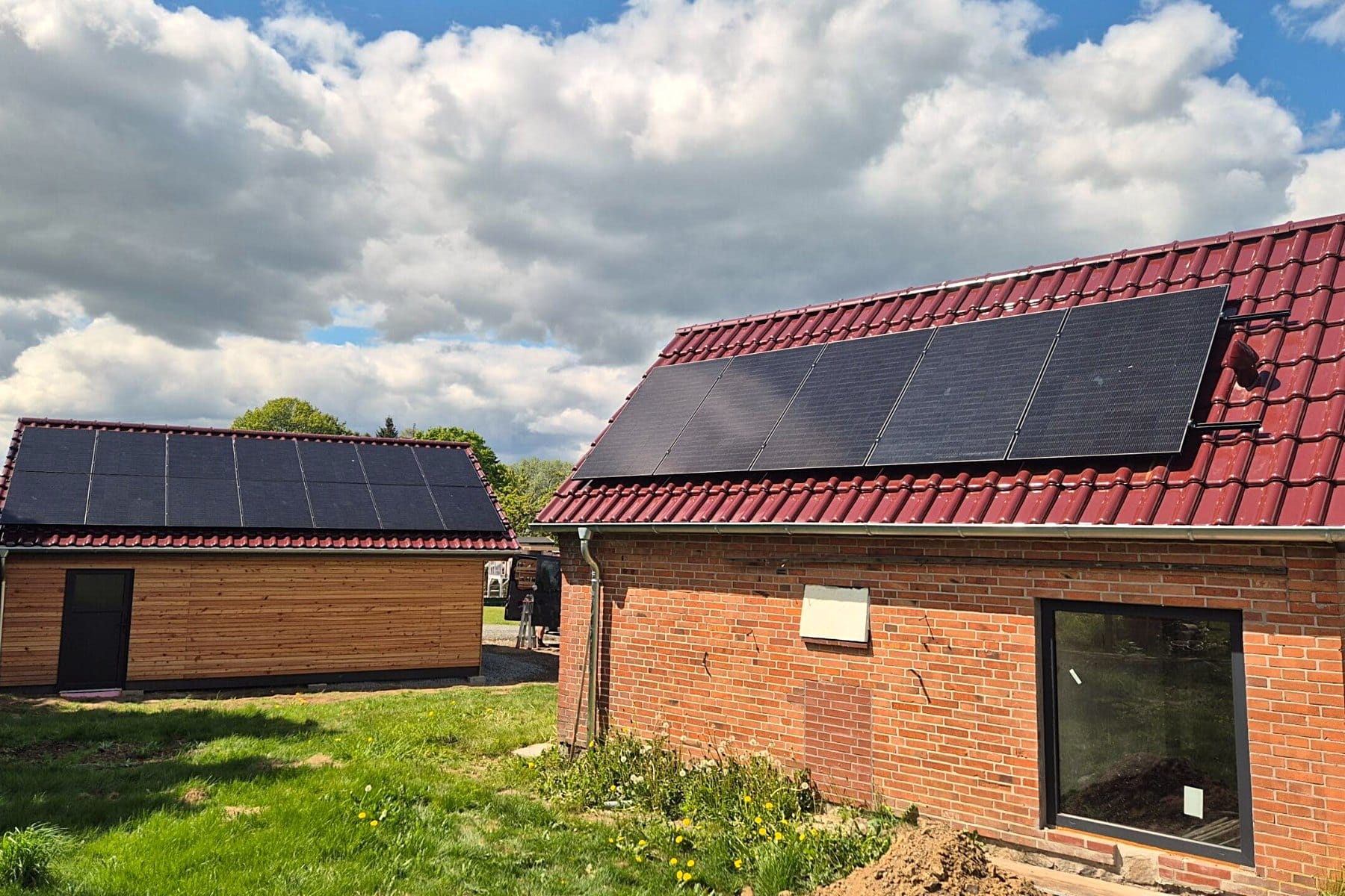 Photovoltaikanlage auf dem Ziegeldach eines Wohnhauses mit Holzfassaden-Nebengebäude – Zimmerei Stange bei Kiel